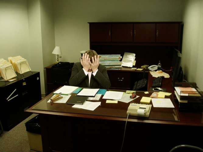 Frustrated man at a desk photo wikipedia cc